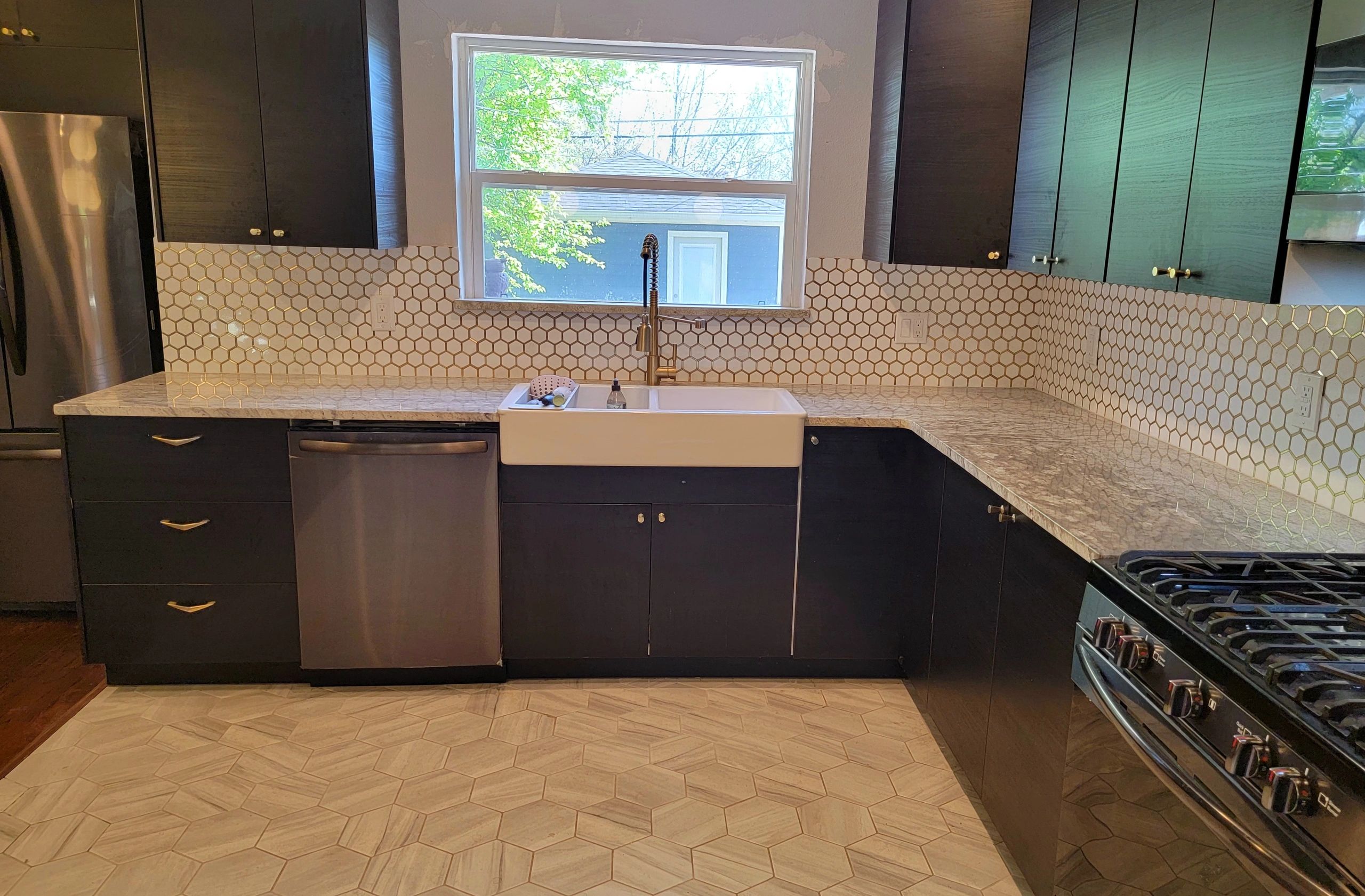 A completed rental kitchen with dark cabinets and geometric tile