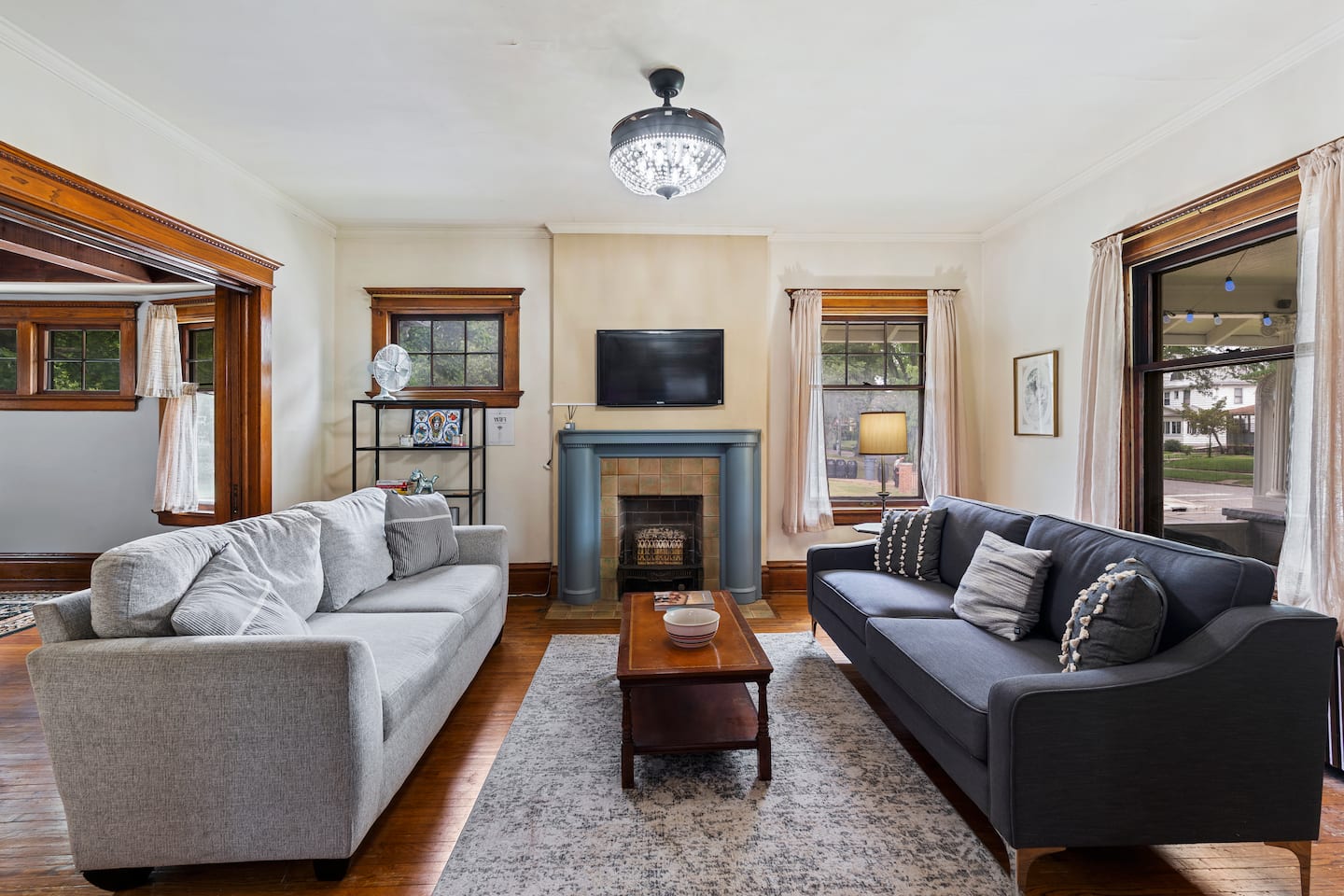 The Katie Lee living room with original woodwork, fireplace, and park views